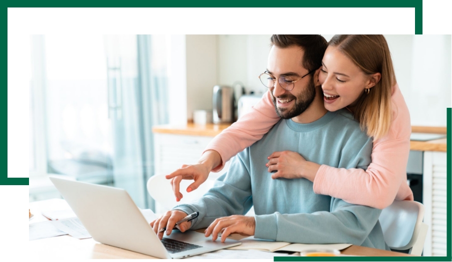 Broad Wealth Management - couple looking at their laptop while smiling